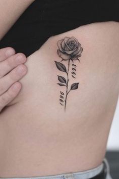 a woman's stomach with a rose tattoo on her side and the word love is written in cursive writing