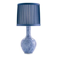 a blue and white lamp with a striped shade on the top, sitting on a table