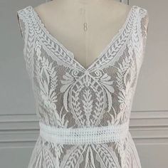 the back of a white dress on a mannequin headdress with an intricate lace pattern