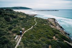 three people walking up stairs to the beach