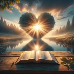 an open book sitting on top of a wooden table next to a heart shaped lake