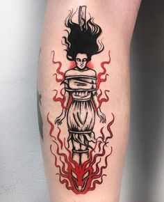 a tattoo on the leg of a person with fire and flames around her legs,