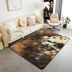 a living room filled with furniture and a rug on top of a hard wood floor