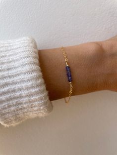 This dainty piece features a gemstone bar made of high quality  tanzanite beads strung along gold filled/sterling silver wire and wire wrapped to a high quality chain. Tanzanite is also the birthstone for anyone born in the month of December. D E T A I L S *Made with AA+ quality micro faceted tanzanite gemstones in beautiful shades of indigo. These measure between 3 and 3.5mm. *Choose between a 14k gold filled chain, Rose gold filled or  sterling silver chain. *It closes with a hallmarked spring Tanzanite Beads, Tanzanite Bracelet, Bar Bracelet, Tanzanite Gemstone, Bracelet Gemstone, Bar Bracelets, Dainty Bracelets, December Birthstone, Jewelry Inspo