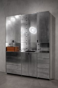 an industrial style kitchen with stainless steel cabinets and drawers, including a sink in the center