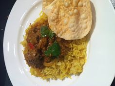 a white plate topped with rice, meat and pita bread on top of it