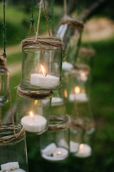 mason jar filled with candles hanging from strings