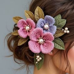 a close up of a woman's head wearing a flower and pearl hair clip