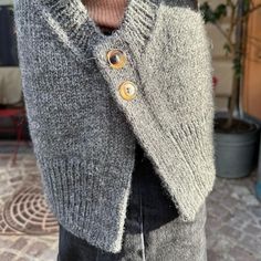 a person wearing a sweater with buttons on it