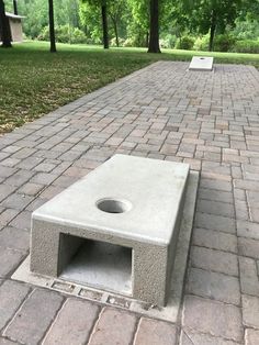 a cement bench sitting on top of a brick walkway