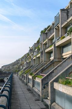 a row of concrete buildings with plants growing on the balconies