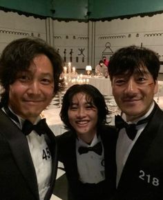 three men in tuxedos posing for a photo