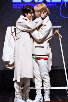 two people standing next to each other on a stage