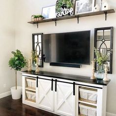 a flat screen tv mounted to the side of a white wall in a living room