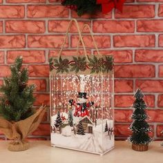 a small christmas bag sitting on top of a table next to a potted tree