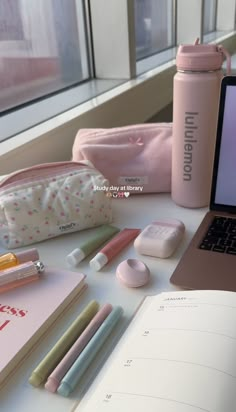 an open laptop computer sitting on top of a table next to a notebook and pencils