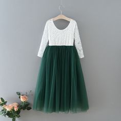 a white and green dress hanging on a hanger