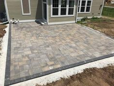 a patio being built in front of a house with brick pavers on the ground