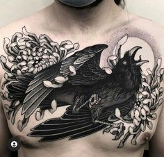 a man with a tattoo on his chest has a crow and flowers in it's back