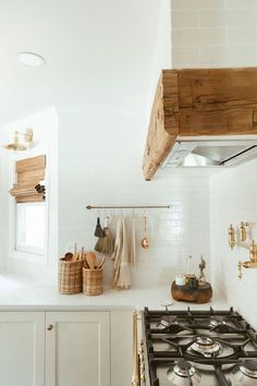 a stove top oven sitting inside of a kitchen next to a wooden shelf above it