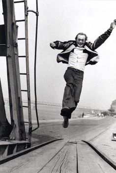 a man is jumping in the air on a boat ramp with his arms outstretched and legs spread out