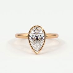 a pear shaped diamond engagement ring in yellow gold