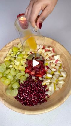 someone is pouring fruit into a bowl