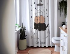 a cat shower curtain with two cats in the rain on it's side, and a potted plant next to it