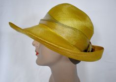 A vintage 1980s saffron yellow woven straw cloche style sun hat with an antique gold wide ribbon band and a pale copper silk rose with metallic gold edges.  The hat was made in USA by Plaza  suite by Betmar.  The hat has a 1/2 inch rip at the back of the crown and a 1 inch green mark on the inner band.  The brim is 4 inches wide at the front, the crown is 4 inches tall, 7 inches front to back and 6 inches side to side measured across the top, 24 inches around the inner gros grain band.  7 oz., boxed Please also follow me on Instagram at ChrisMartinDesigns Gold Fedora Straw Hat For Kentucky Derby, Gold Brimmed Straw Hat, Gold Wide-brim Straw Hat For Kentucky Derby, Gold Brimmed Straw Hat For Kentucky Derby, Gold Fedora For Kentucky Derby, Gold Wide Brim Straw Hat For Kentucky Derby, Adjustable Gold Straw Hat For Kentucky Derby, Fitted Gold Summer Hat, Adjustable Gold Cloche Hat