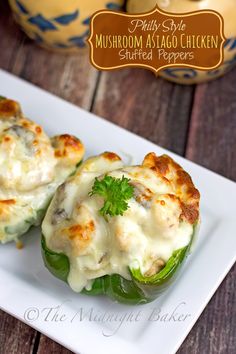 two stuffed green peppers on a white plate