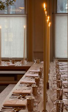 a long table is set with candles and place settings