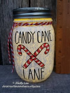 a mason jar with candy canes painted on it and the words candy cane lane