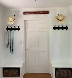 the entryway is clean and organized with hats on hooks, baskets, and umbrellas