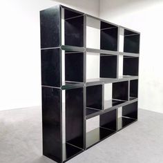 a black and white book shelf sitting on top of a floor