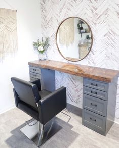 a chair sitting in front of a desk with a mirror on it