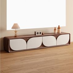 a white and brown entertainment center in a living room with wood flooring next to a large window