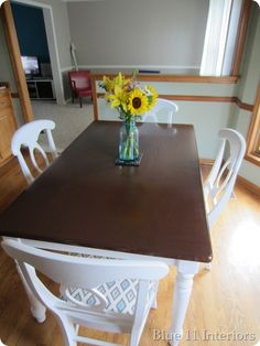 a vase with sunflowers is sitting on the dining room table