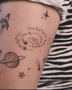 a woman's arm with an image of planets and stars on it, in black ink