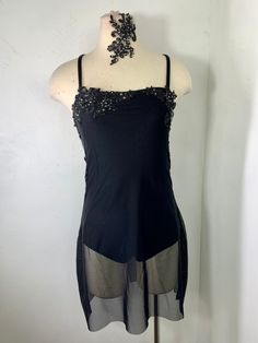 a mannequin wearing a black top with silver details