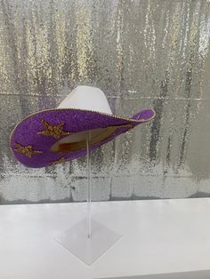 Lets go Tigers!! If you are heading to a tailgate party, football game or attend LSU, this hat is for you! Ready for those who want to stand out and have the most perfect accessory to their outfit. It is also a perfect birthday gift, graduation gift or Christmas gift to a family member or friend! This hat features: White straw hat Purple rhinestones on both brims Gold Stars on both brims Matching purple hat band Gold rhinestone trim on edges Sizing: Our white hats are a one size fits all! The ba Fun Costume Hats With Curved Brim For Parties, Fun Adjustable Hats For Carnival, Fun Party Costume Hat With Curved Brim, Fun Party Cap Hat, Fun Party Cap, Fun Wide Brim Party Costume Hats And Headpieces, Fun Wide Brim Costume Hats And Headpieces For Party, Themed Brimmed Party Hat, Novelty Wide Brim Party Hat