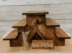 a wooden stand with some flowers in it and a vase next to it that says save us sweet