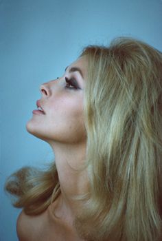 a woman with long blonde hair looking up