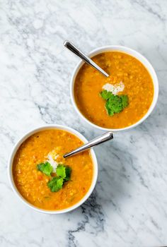 two bowls of soup on a marble table