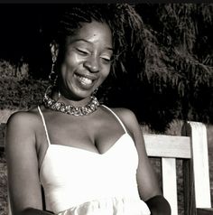 a black and white photo of a woman sitting on a bench with her eyes closed