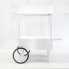 a small white cart with wheels and a table top on one side, against a white background