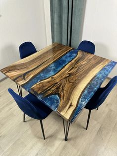 a table with blue chairs around it and a wooden slab on the top that has been made to look like an ocean scene