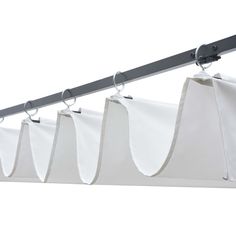 several white bags hanging from a metal bar on a clothes line with two black handles