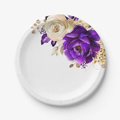 a white paper plate with purple flowers painted on the side and gold flakes around it