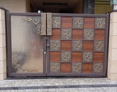 a large metal gate with wooden panels and decorative designs on the front entrance to a building