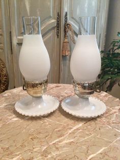 two glass vases sitting on top of a table